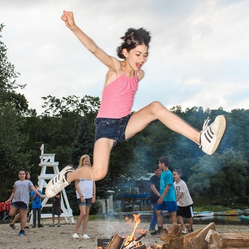 girl jumping over campfire